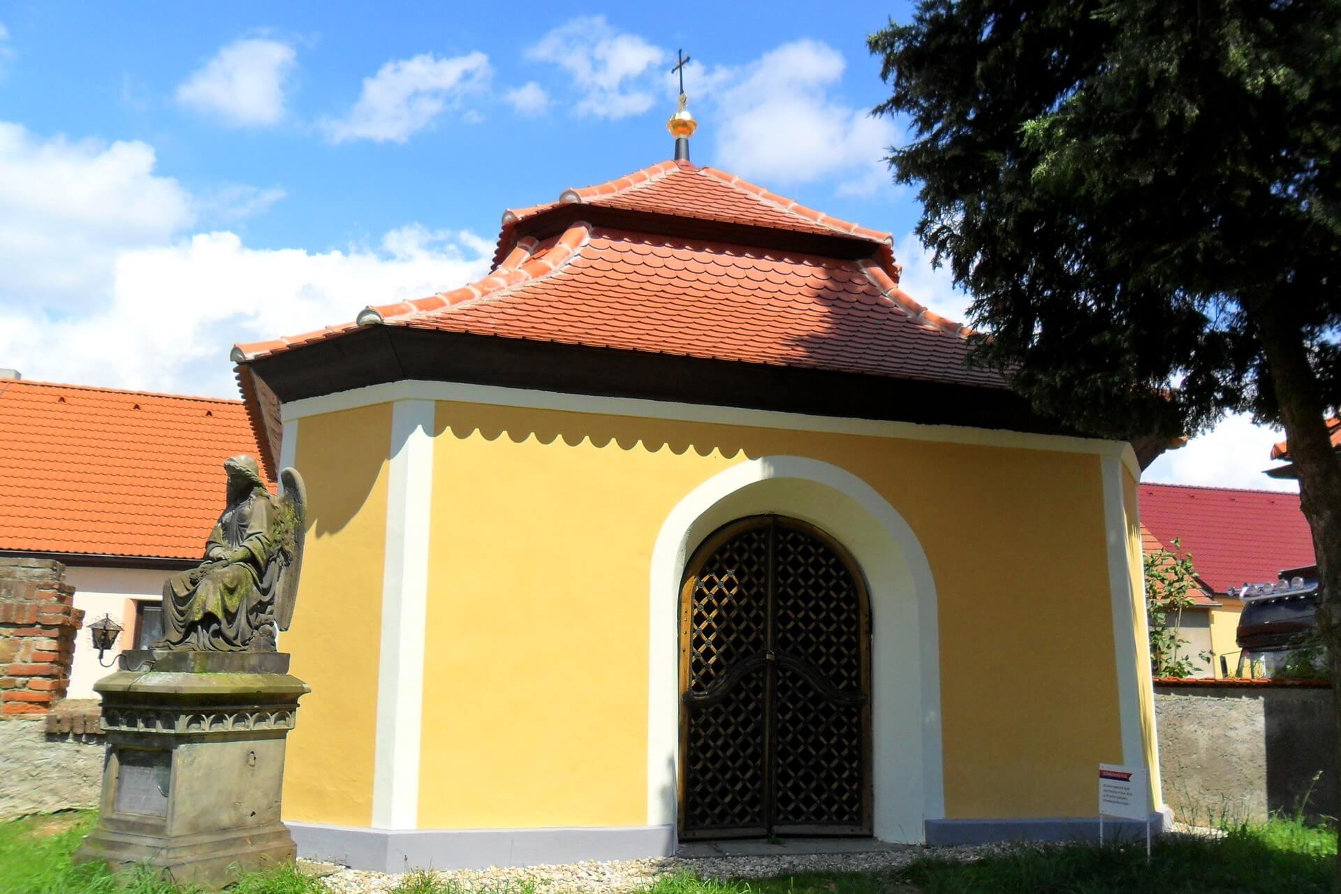 Vstup do kostnice ve Zdislavicích s kovanou mříží ve dveřích