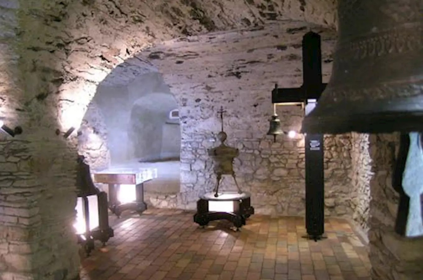 Expozice českého zvonařství s historickými zvony v kamenném sklepení zámku Vrchotovy Janovice