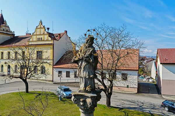 Socha svatého Jana Nepomuckého a novorenesanční radnice na náměstí v Křivsoudově