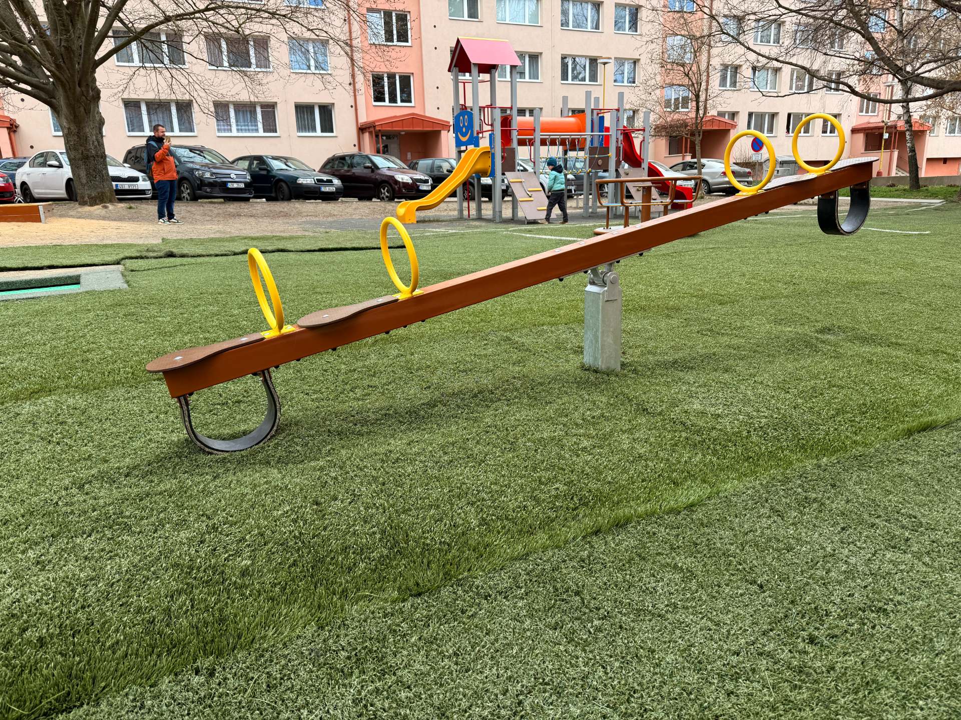 Vahadlová houpačka na dětském hřišti mezi panelovými domy na vlašimském sídlišti