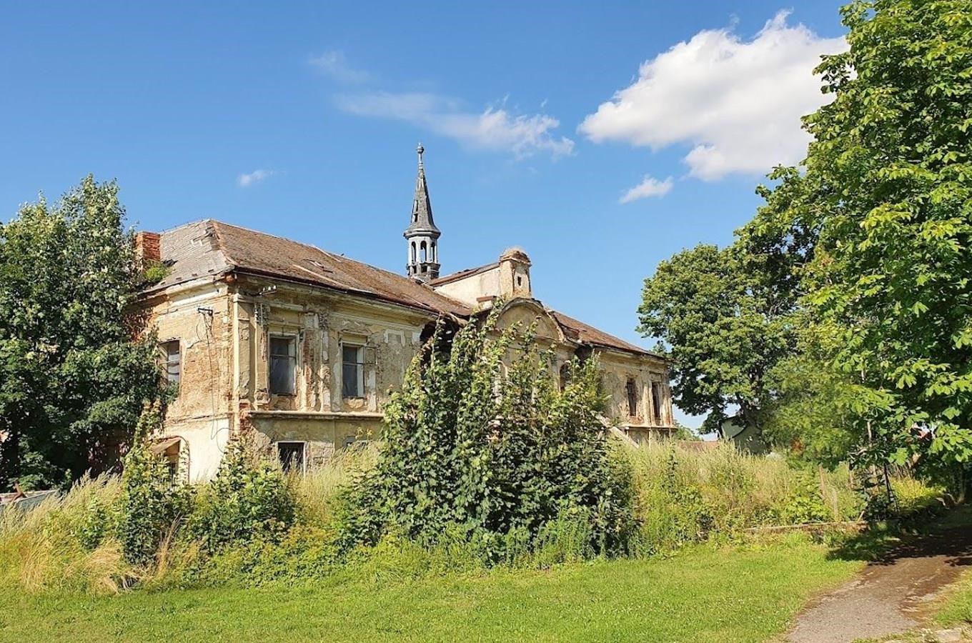 Barokní zámek v Pravoníně s věžičkou, zarostlý zelení