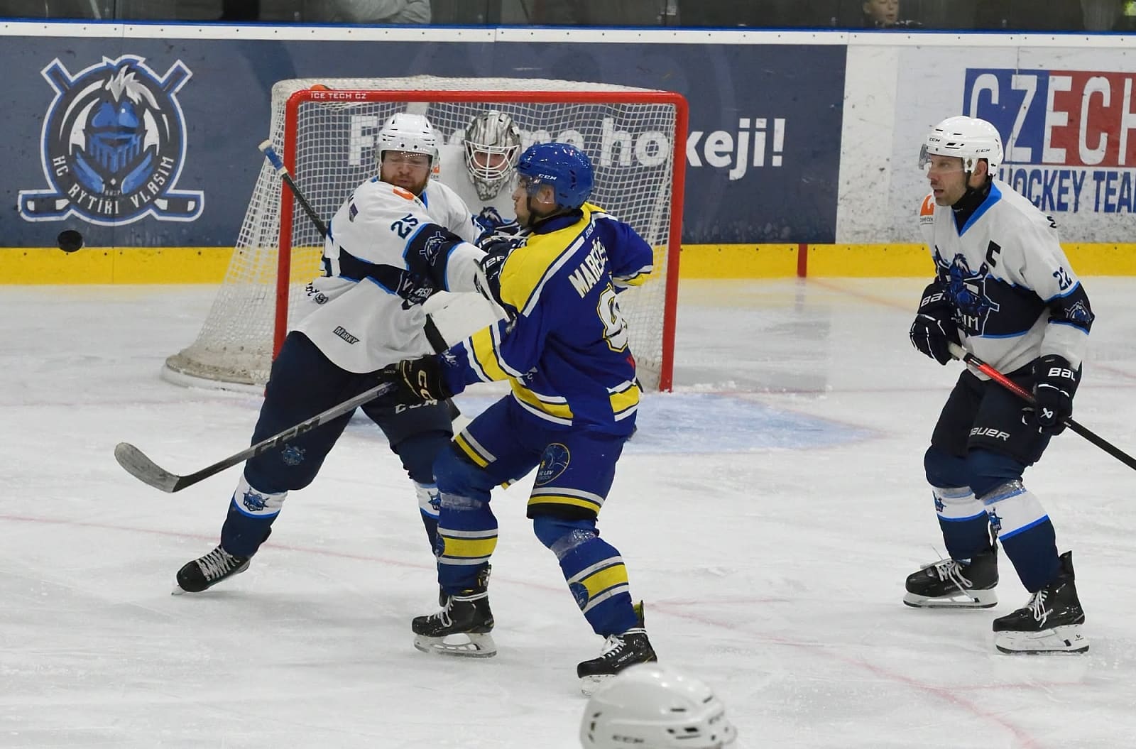 Souboj hráčů Vlašimi a Benešova u mantinelu s logem HC Rytíři Vlašim